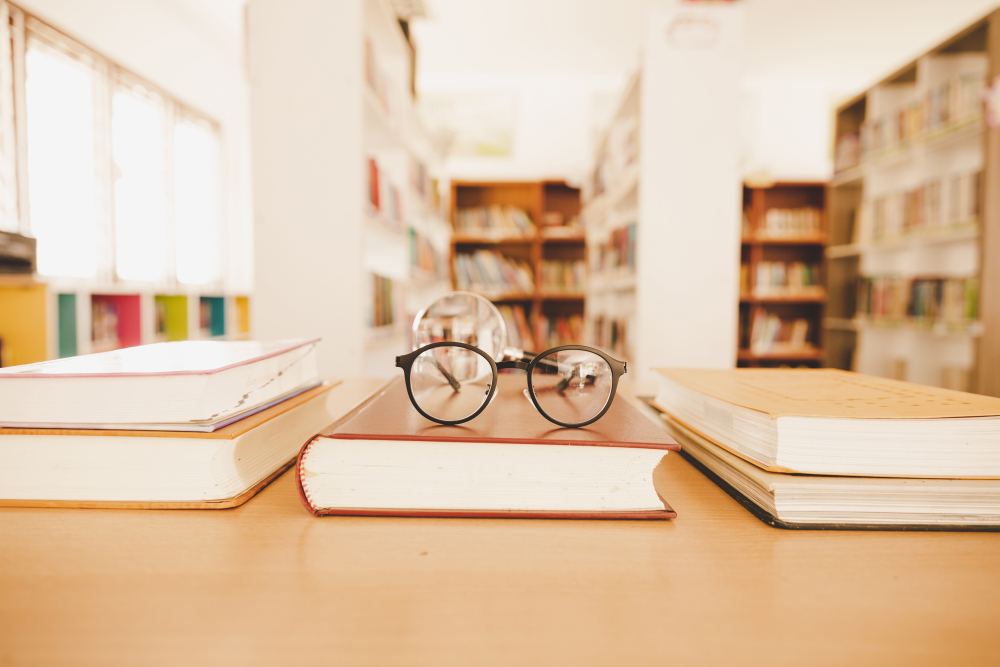 book in library with old open textbook, stack piles of literatur